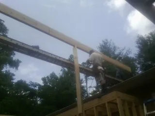 Carpenter setting a ridge beam over a new addition frame — Ice Dam Removal by Roofing Brothers in Owens Cross Roads