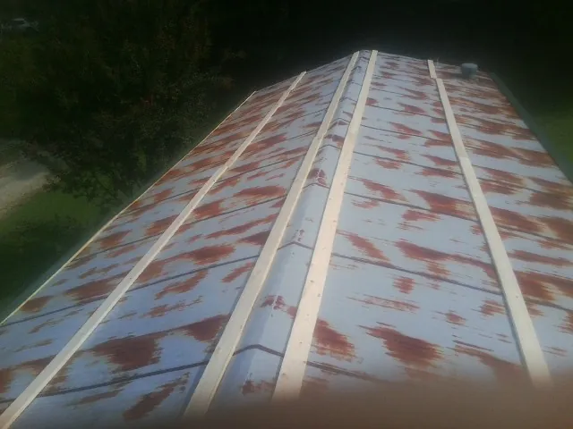Rusted metal roof panels with new wood purlins before replacement — Storm Damage Roof Repair in Owens Cross Roads by Roofing Brothers