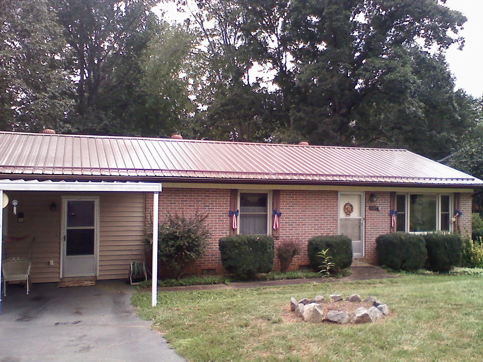 Bronze metal roof and carport on a brick ranch home — Roof Repair work by our crew in Owens Cross Roads