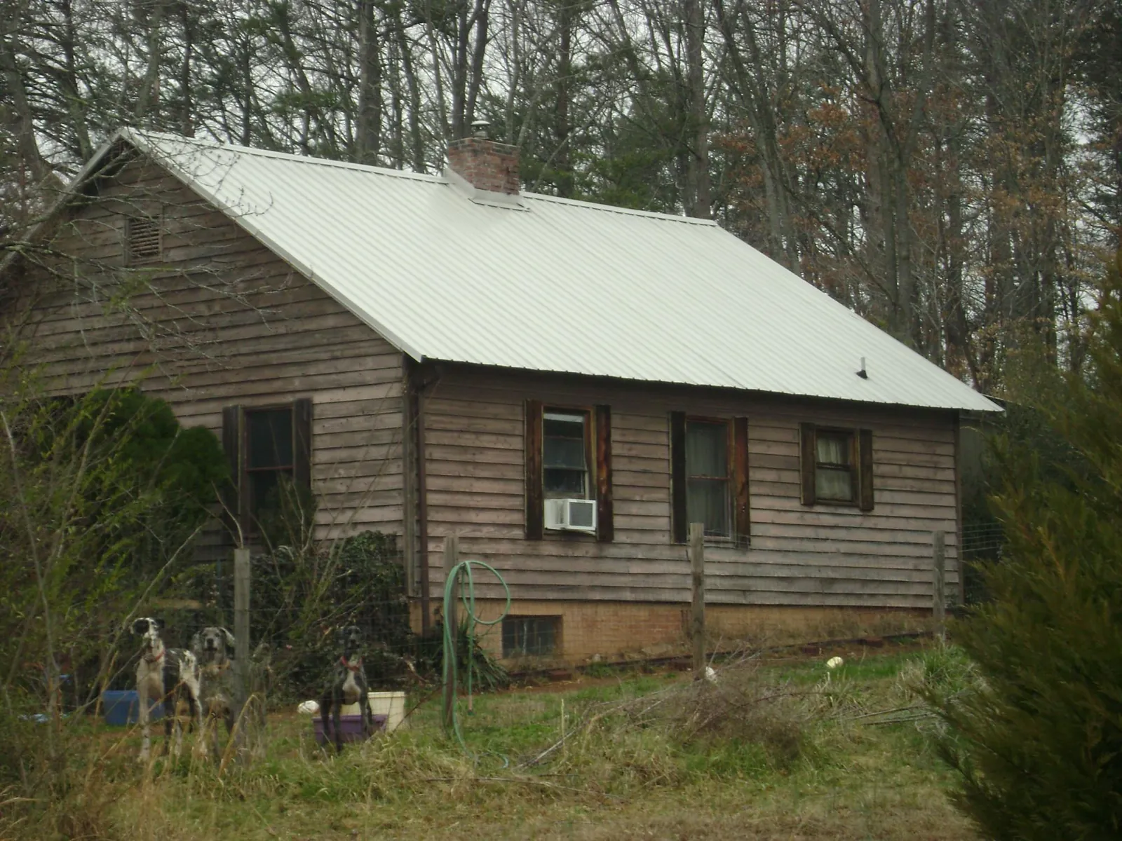 White metal roof on an old wood sided farmhouse, from a Metal Roof Installation job in Owens Cross Roads